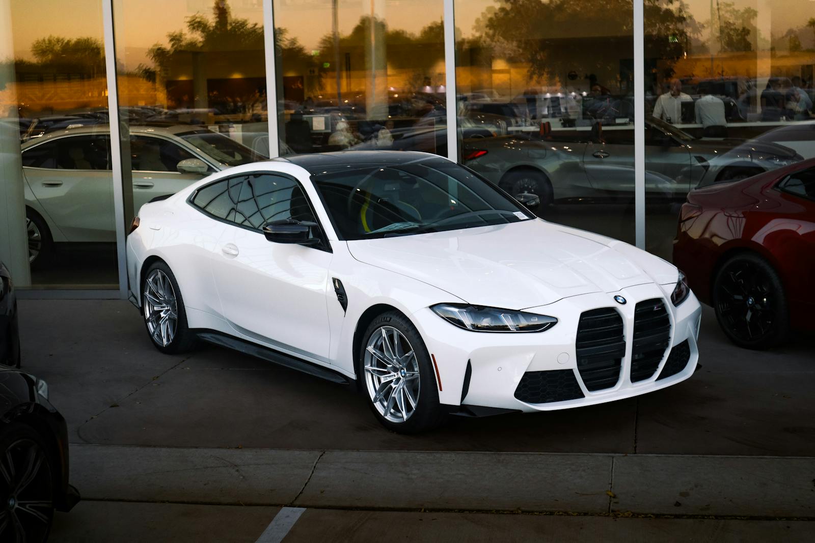 Modern white sports car showcased in a sleek showroom setting, highlighting its design.
